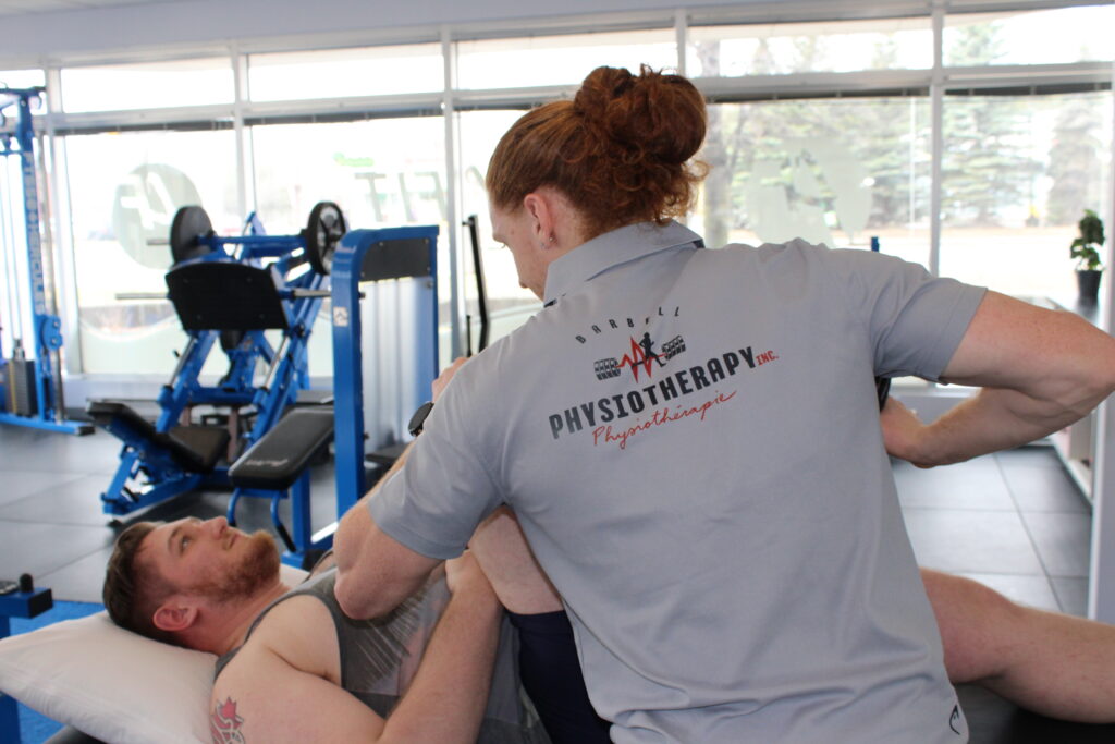 Therapist stretching client’s leg