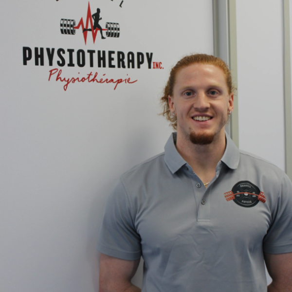 Physiotherapist standing near Barbell Physiotherapy sign
